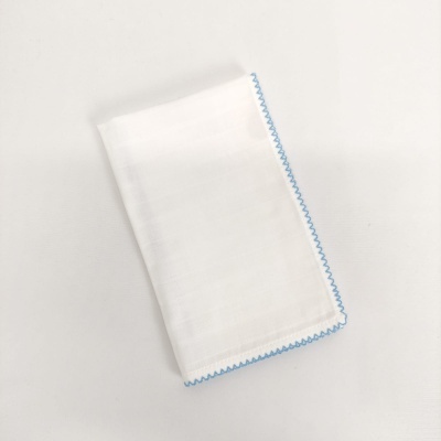 toalhete branco com costura azul sobre fundo branco