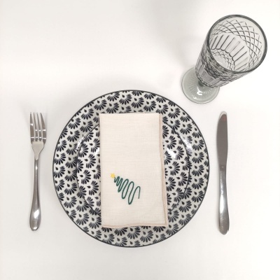 Conjunto de prato, guardanapo, talheres e copo sobre fundo branco