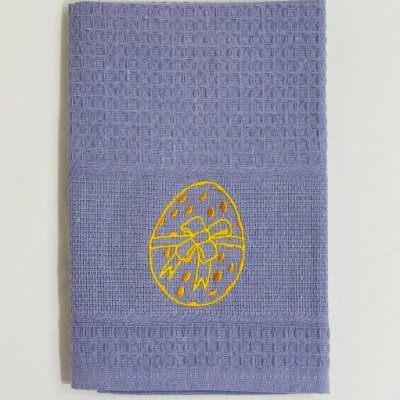 Toalha lilás com bordado amarelo de ovo decorado com laço