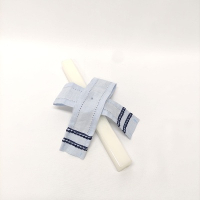 Ferro de engomar branco com pega de tecido azul claro com riscas azuis escuras