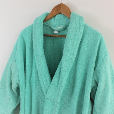 Roupão verde água de tecido felpudo pendurado em cabide