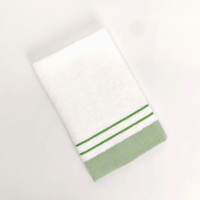 Toalha branca com detalhes verdes numa extremidade sobre fundo branco