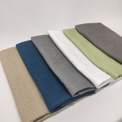 Seis toalhas de mão coloridas e texturizadas empilhadas.