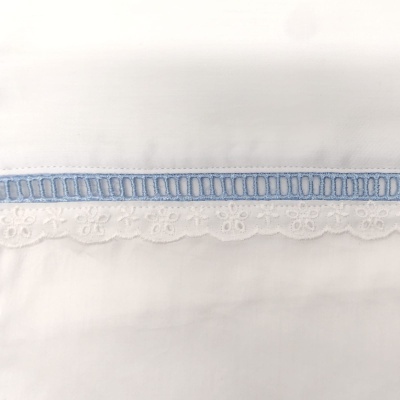 Tecido branco com bordado azul e renda branca decorativa