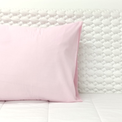 Almofada rosa clara sobre colchão branco com capa texturizada