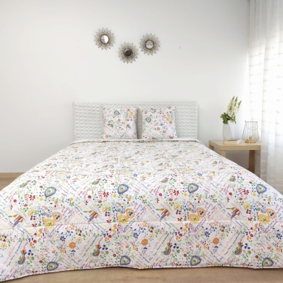 cama com colcha e fronhas florais coloridas em ambiente branco e madeira clara