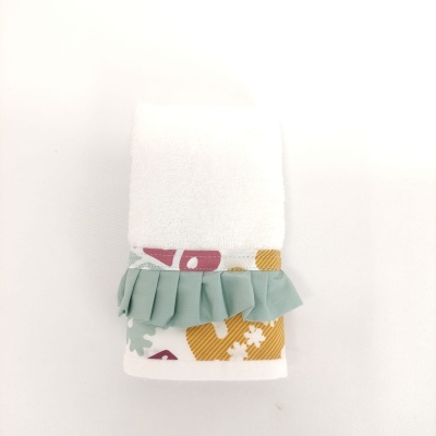 Toalha branca com padrão colorido e babado verde