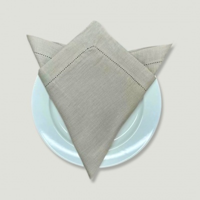 Guardanapo de pano cinza claro decorativo sobre prato branco