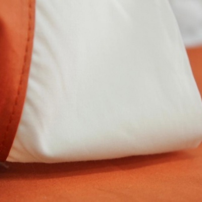 Tecido branco e laranja sobre superfície laranja