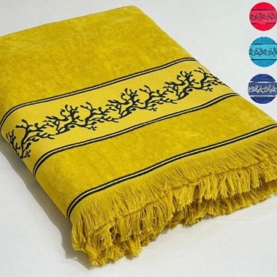 Toalha amarela com franjas e padrão preto de ramos e linhas horizontais