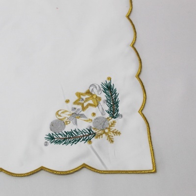 Toalha branca com bordado natalício em dourado, verde e prateado no canto e borda dourada.