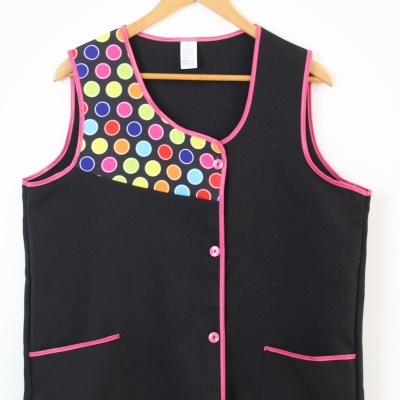 Colete preto com detalhes rosa e padrão de círculos coloridos na parte superior esquerda