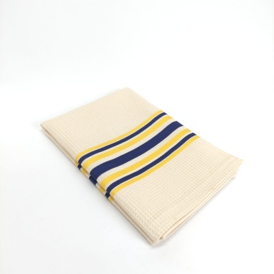 Toalha bege com riscas amarelas e azuis