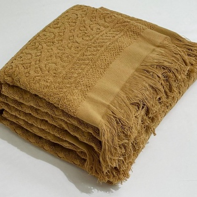 Toalha de banho castanho claro com padrões em relevo e franjas