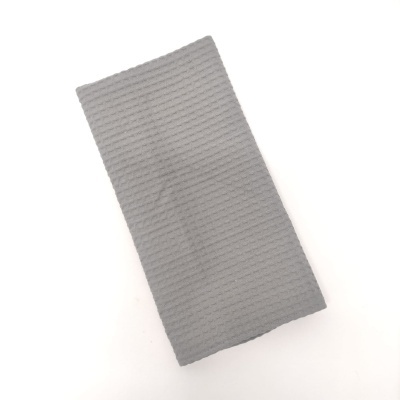 Toalha cinza com textura riscada sobre fundo branco