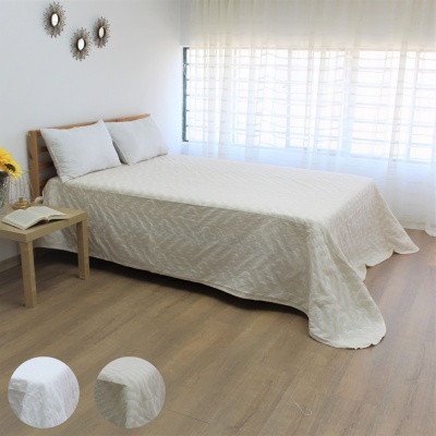 Cama com colcha branca texturizada em quarto moderno