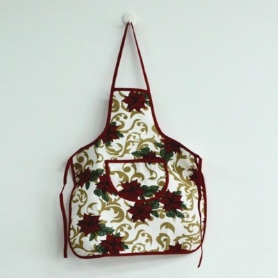 Avental de cozinha floral com bolso e acabamentos em bordo pendurado na parede