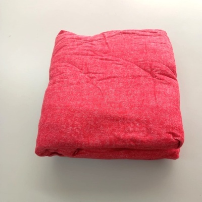 Cobertor vermelho dobrado sobre superfície branca