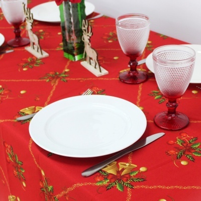 Toalha de mesa natalícia vermelha com prato branco e copos de vidro vermelho