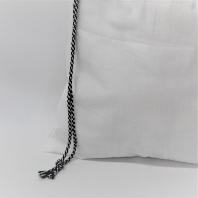 Almofada branca com cordão preto e branco na lateral