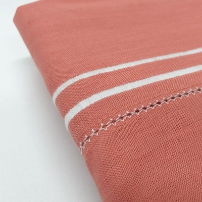 Pano cor terracota com linhas brancas paralelas e costura decorativa