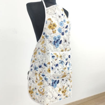 Avental branco com padrão floral colorido em manequim preto