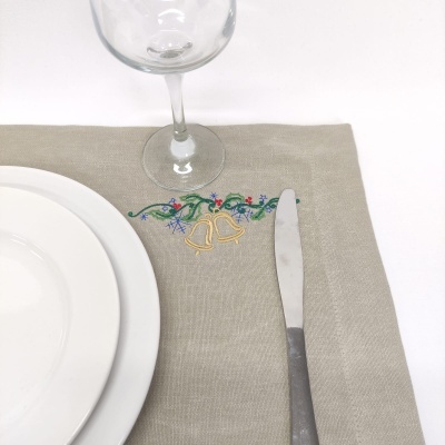 Jogo americano cinzento com bordado de sinos dourados e flores com prato, faca e taça