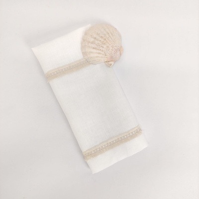 Pano branco com detalhes bege e concha clara sobre fundo branco