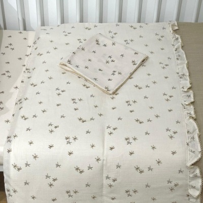 Conjunto de tecido para mesa com padrão de pequenas flores castanhas e verde em fundo cru.