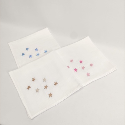 Três panos brancos com estrelas bordadas em azul, castanho e rosa