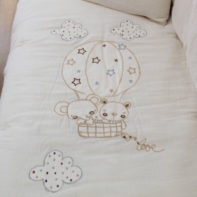 Colcha branca com bordado de balão de ar quente e ursos