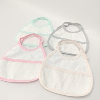 Quatro babetes para bebé em malha branca com bordas coloridas em verde, cinzento, rosa e bege