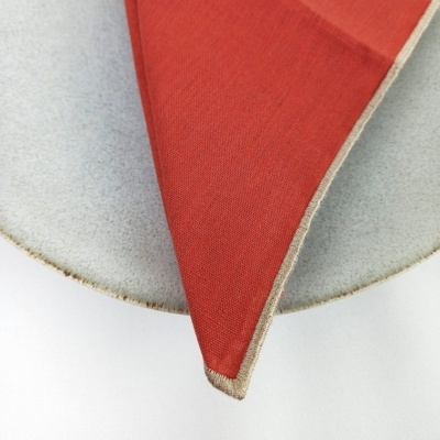 Guardanapo de tecido terracota sobre prato cinzento claro