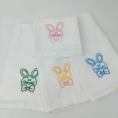 Paninhos de cozinha brancos com coelhos bordados em várias cores.