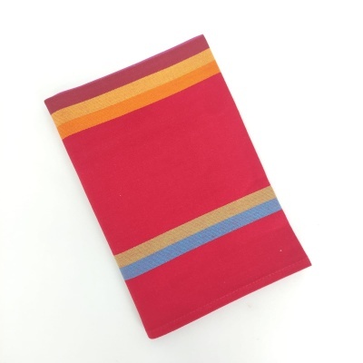 Toalha vermelha com faixas coloridas sobre fundo branco