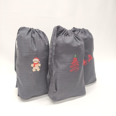 três sacos cinza escuro com desenhos de Natal