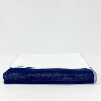 Toalha branca com borda azul escura e faixa cinzenta listrada dobrada