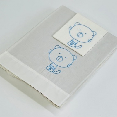 Conjunto têxtil branco com desenho azul de gato infantil.