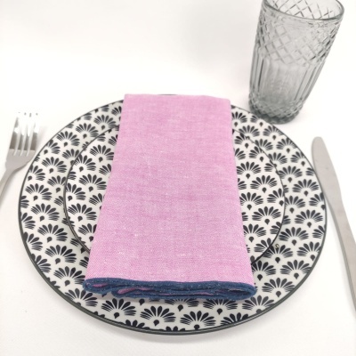 Conjunto de jantar com prato decorado, guardanapo rosa, talheres e copo transparente