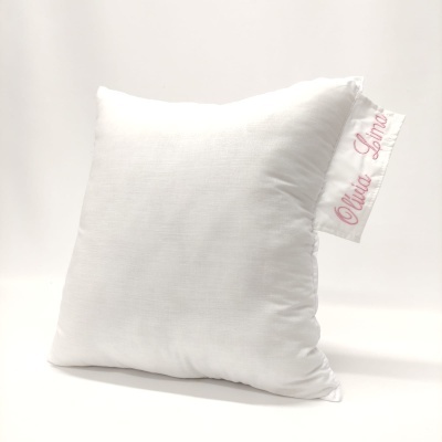 Almofada branca quadrada com etiqueta 'Olito Lima' cor-de-rosa na lateral