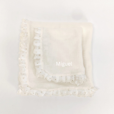 Guardanapo branco com borda rendada e nome 'Miguel' bordado