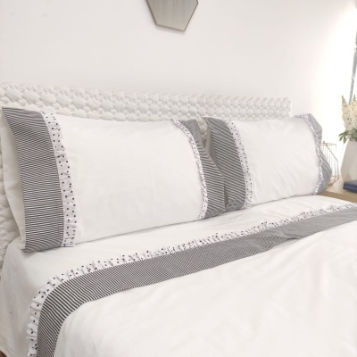 Conjunto de roupa de cama branco com detalhes cinzentos e bordado floral