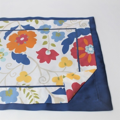 Toalha ou guardanapo de tecido com padrão floral colorido e borda azul escura