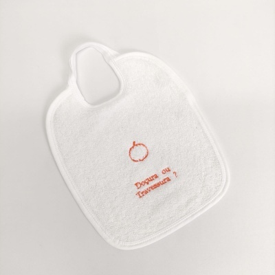 Babete branco com bordado laranja de maçã e texto 'Doçura ou Travessura?' em fundo branco