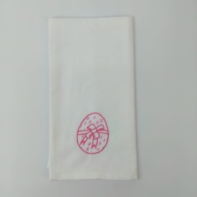 Guardanapo branco com bordado rosa de ovo decorado com laço