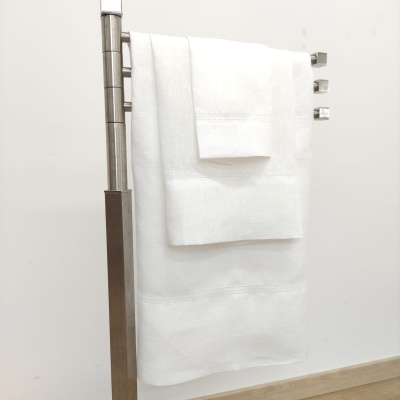 Toalhas brancas penduradas em suporte metálico