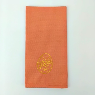 Guardanapo laranja com bordado de ovo de Páscoa amarelo