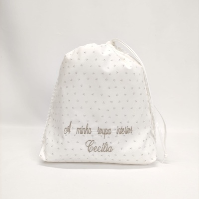 Saco branco com padrão de flores pequenas e texto bordado