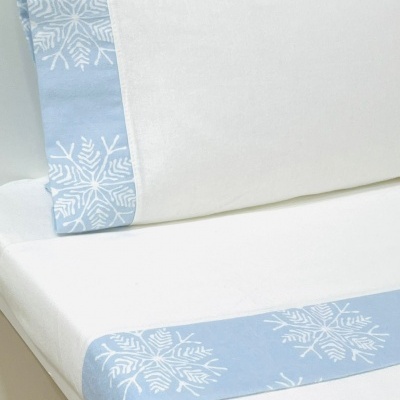 Jogo de cama branco com detalhes azuis e padrão de floco de neve