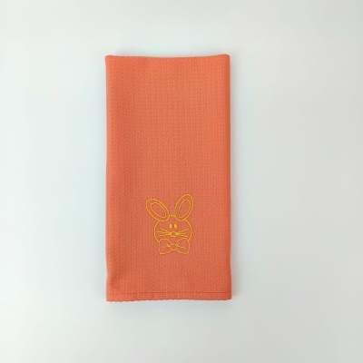 Toalha laranja com bordado de coelho amarelo